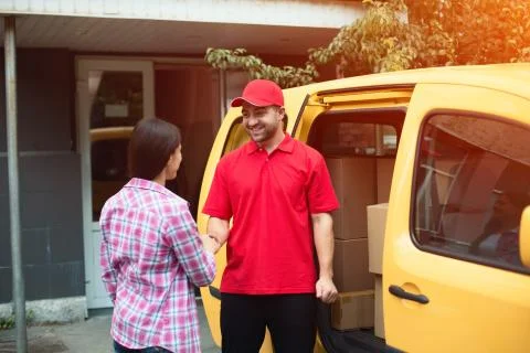Delivery man shaking hands with client. Stock Photos