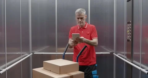 Delivery man taking the elevator Stock Footage 308916339