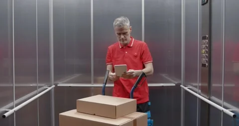 Delivery man taking the elevator Stock Footage 308916340