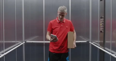 Delivery man taking the elevator Stock Footage 308916359