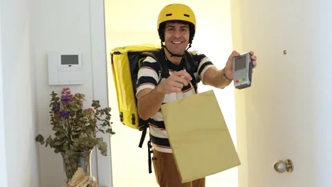 Delivery man with thermal backpack holding credit card reader terminal Stock Footage 318096103