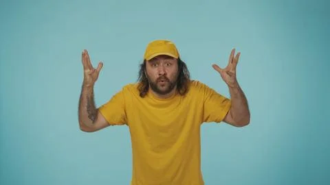 Delivery man in uniform looking at the camera, making head exploding gesture and Foto stock