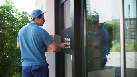Delivery Man Using Intercom System For Entry Stock Footage 313363937