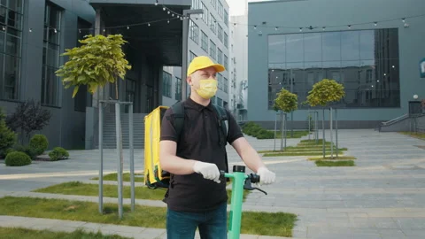 Delivery man wearing mask due to the emergence of the Covid 19 virus, riding a Stock Footage 171978356