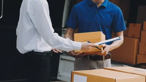 Delivery man wearing uniform unloading parcel Stock Footage 303457798
