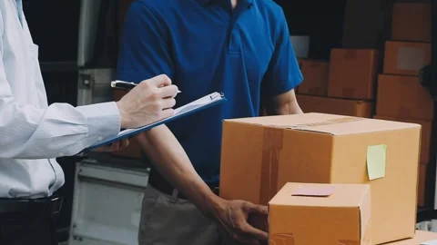 Delivery man wearing uniform unloading parcel Stock Footage 303457802