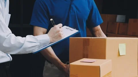Delivery man wearing uniform unloading parcel Stock Footage 303457803