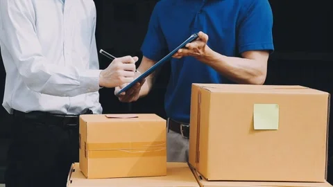 Delivery man wearing uniform unloading parcel Stock Footage 303457804