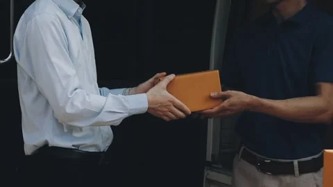 Delivery man wearing uniform unloading parcel Stock Footage 303457806