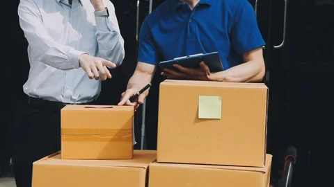 Delivery man wearing uniform unloading parcel Stock Footage 303457807