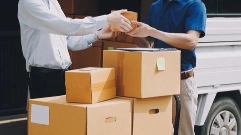 Delivery man wearing uniform unloading parcel Stock Footage 303457809