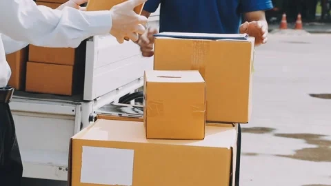 Delivery man wearing uniform unloading parcel Stock Footage 303457811