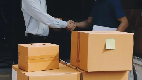 Delivery man wearing uniform unloading parcel Stock Footage 303457812