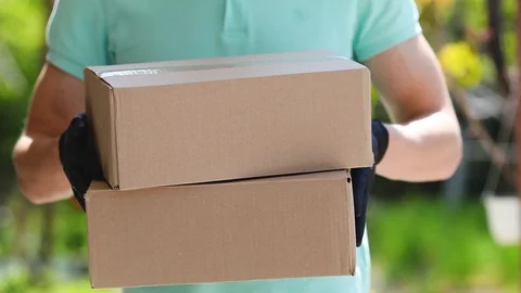 The delivery man will stretch cardboard boxes in  gloves . Stock Footage 129548994