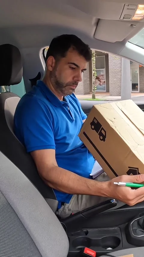 Delivery man writing notes inside a car Stock Footage 286407998
