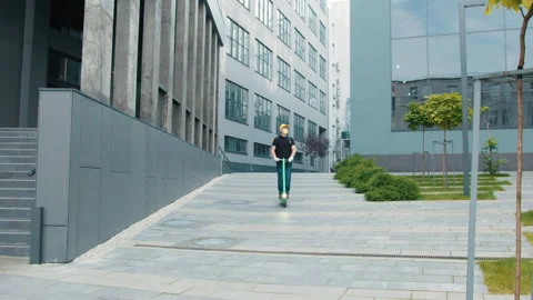 A delivery man with a yellow backpack, face mask in the video on an electric Stock Footage 171973551