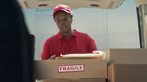 Delivery Manager Searching among Boxes with Fragile Parcels in Car Video stock 280374129