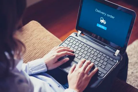 "Delivery order" on the screen. Hands over the keyboard on laptop. Stock Photos