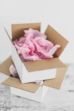 Delivery parcel boxes stacked on top of each other with pink paper inside, co Stock Photos