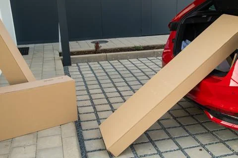 Delivery process with cardboard boxes being unloaded from vehicle trunk Stock Photos