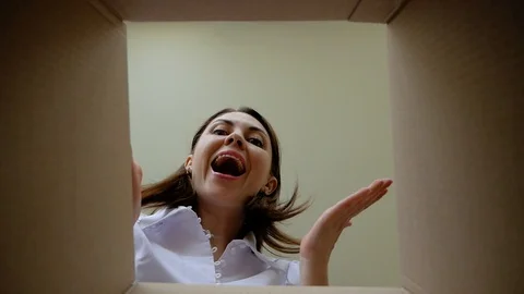 Delivery, relocation and unpacking concept. Smiling happy young girl opening a Video stock 102443912