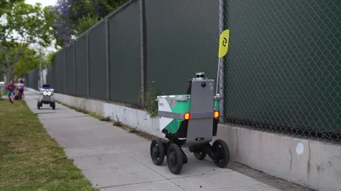 Delivery robot meets another robot on its way to deliver package Stock Footage 243639812