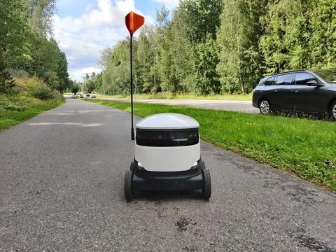 Delivery robot operating on a sidewalk in Espoo, Finland. Six-wheeled zero-em Stock Photos