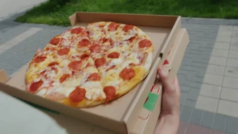 Delivery service concept with hands holding open box with fresh pizza Stock Footage 345203264