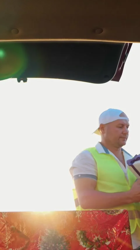 Delivery service. deliveryman loads boxes. gift boxes in car. beautifully Stock Footage 317704331