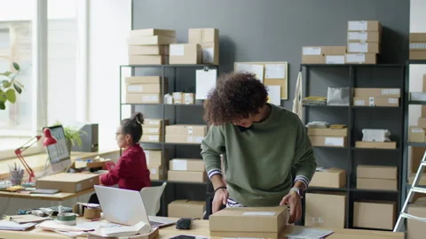 Delivery Service Worker Preparing Parcel and Talking on Phone Stock Footage 228492385