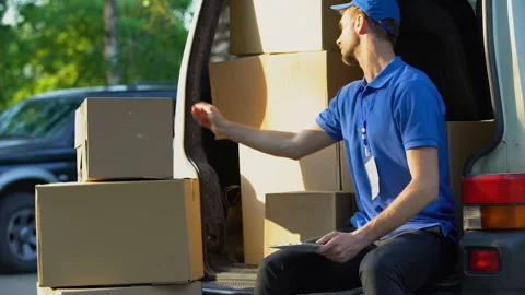 Delivery worker checking parcel amount in van, stocktaking report on tablet Stock Footage 91244511