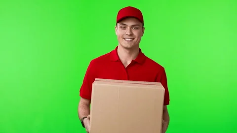 Delivery worker in red uniform offering parcel to camera Stock Footage 276332255