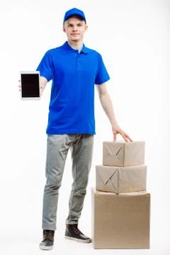 Delivery worker shows a tablet screen with info for three parcels. Stock Photos