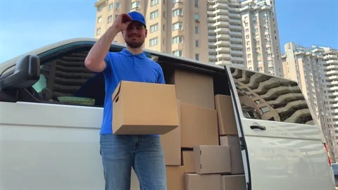 Delivery worker smiles while holding box. Reliable delivery concept Stock Footage 337612711