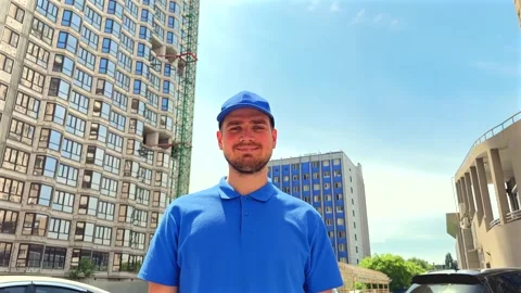 Delivery worker stands confidently. Urban logistics and delivery service concept Stock Footage 337612732