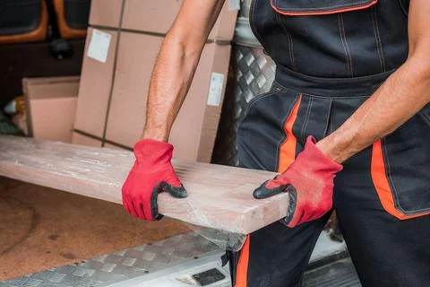 Delivery Worker Unloading Packages from Cargo Vehicle Efficiently Stock Photos