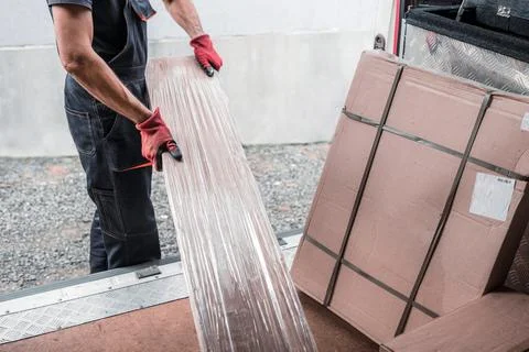 Delivery Worker Unloading Packages from Cargo Vehicle Efficiently Stock Photos