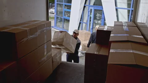 Delivery workers loading truck with cardboard boxes. Media. Putting parcels into Stock Footage 279620325