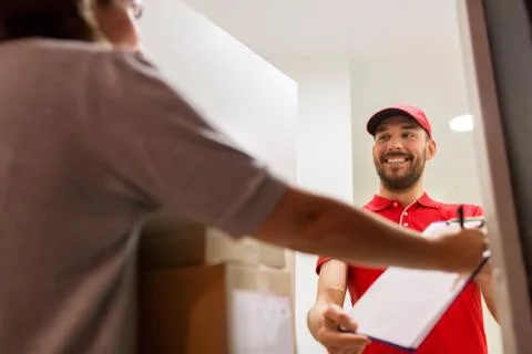 Deliveryman and customer with parcel boxes at home Stock Photos