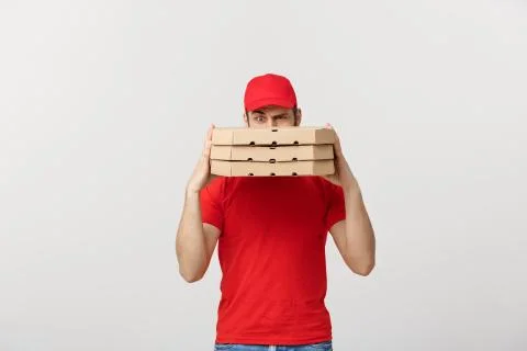 A Deliveryman hidden behind a large stack of pizza boxes he is carrying Stock Photos
