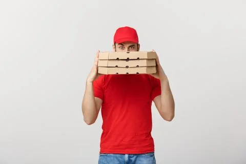 A Deliveryman hidden behind a large stack of pizza boxes he is carrying Foto stock