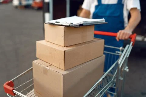 Deliveryman holds cart with stack of boxes Foto stock