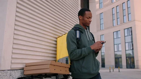 A deliveryman with a phone outside Stock Footage 217363917