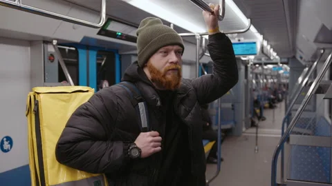 Deliveryman is standing in subway car with a backpack.Concept of urban services Stock Footage 236089062