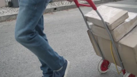 Deliveryman wheeling cart with parcels 스톡 동영상 155376089