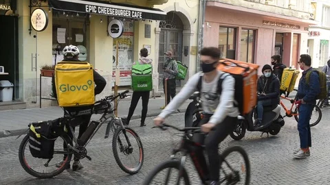 A deliverymen for Uber Eats and Glovo in center of Lviv. Stock Footage 128631125