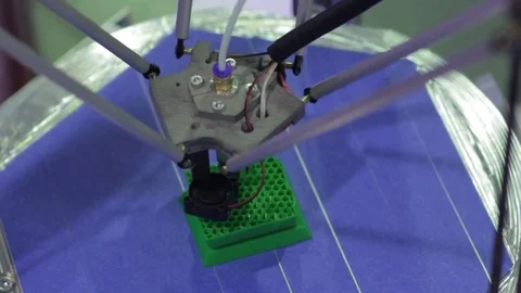 Delta 3D printer prints the green part with cells (top view Stock Footage 72503386
