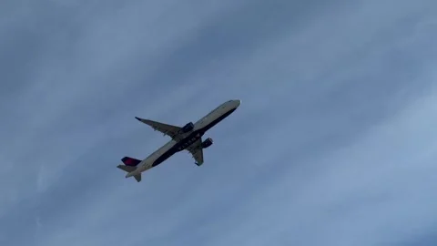 Delta Airlines passenger jet airplane flying across the sky after takeoff Stock Footage 324280853