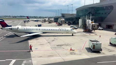 A Delta Connection plane arrive into a gate at Terminal C at Laguardia Airport Stock Footage 313750217