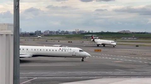 Delta connection planes taxiing down a runway at Laguardia Airport (LGA) Stock Footage 313750206